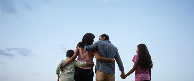 Una familia abrazándose al aire libre.
